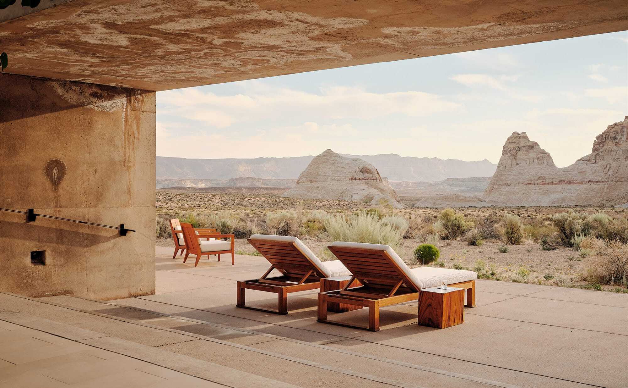 An infinity pool cut into red desert cliffs at a remote luxury retreat.