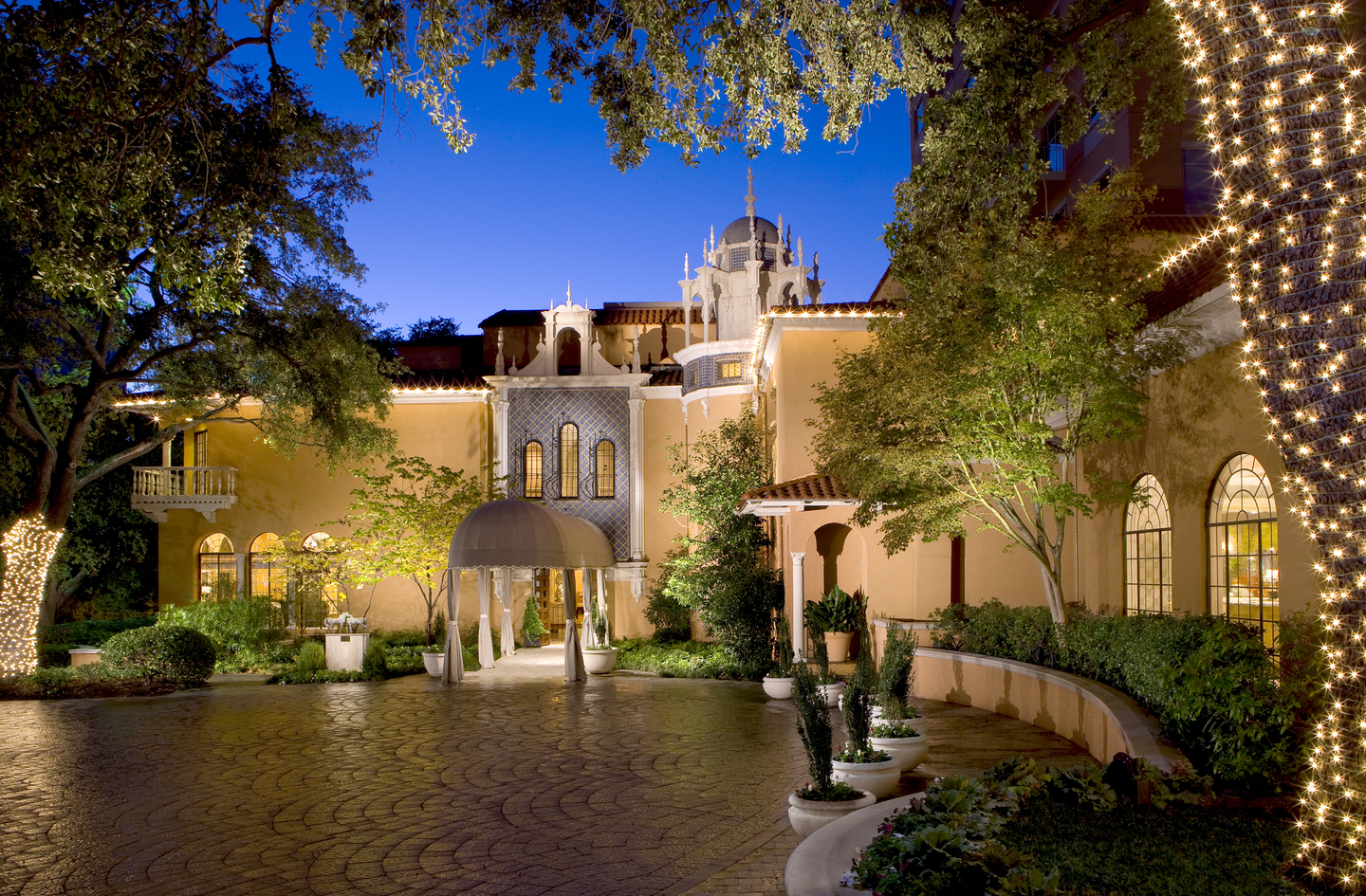 The lantern-lit courtyard entrance of Rosewood Mansion on Turtle Creek at twilight