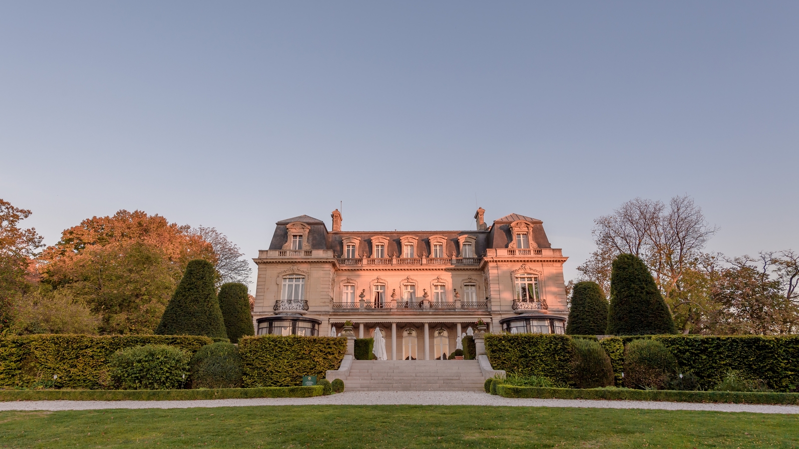 The château at Domaine Les Crayères above its formal gardens in evening light